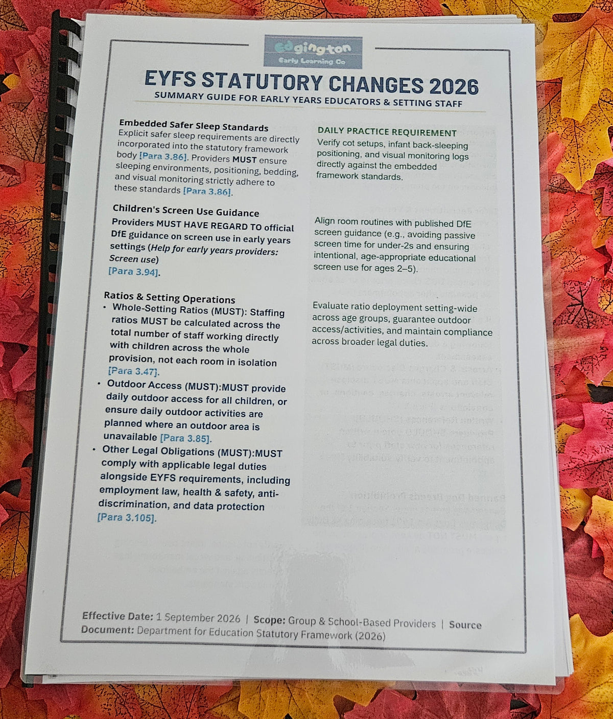 A printed spiral-bound document titled 'EYFS STATUTORY CHANGES 2026' laid flat on a colorful autumn leaf background. The page contains text about early years education settings and statutory requirements, with the 'oligan' logo at the top.